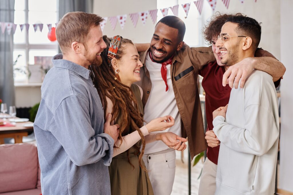 A joyful group of diverse friends celebrates indoors, embodying unity and happiness.